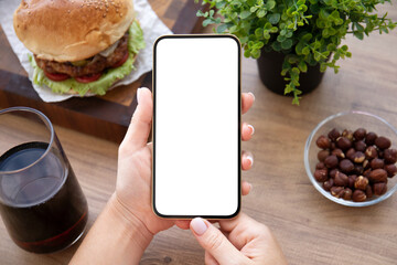 female hands holding phone with isolated screen background burger cafe