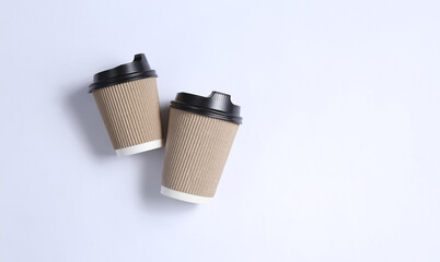 Two cardboard coffee cups on gray background