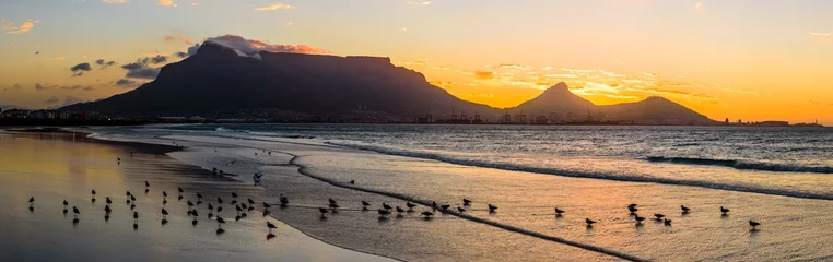 Papier Peint photo autocollant Montagne de la Table Un magnifique coucher de soleil sur la montagne de la Table en Afrique du Sud depuis la plage du lagon.