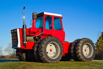 Red four-wheel drive farm tractor and blue sky