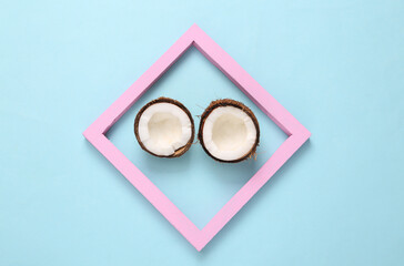 Coconuts in a pink frame on a blue background. Minimal tropical background. Creative layout