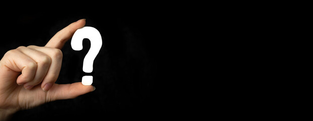 Banner question mark sign in hand. Question icon, symbol on a black background