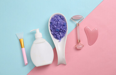 Set of cosmetics and skin care tools on blue pink pastel background