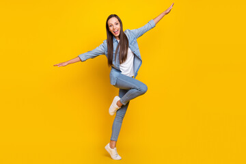 Fototapeta na wymiar Full body photo of impressed young lady hands plane yell wear jeans shirt shoes isolated over yellow color background