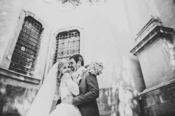 Lovely happy wedding couple, bride with long white dress posing in beautiful city