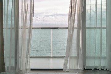 Fototapeta premium Almost evening time of ocean view from hotel balcony with curtains.