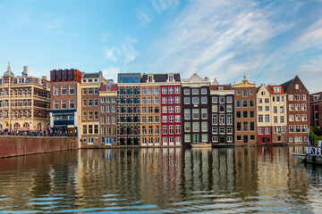 Naklejka premium Amsterdam Houses. The houses stand in the water and have a beautiful reflection. Touristic district Damrak. These houses are famous all over the world. Amsterdam, Holland, Europe