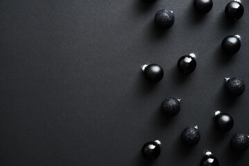 Christmas composition. Black Christmas balls on dark background. Minimal style. New Year postcard design. Flat lay, top view, copy space