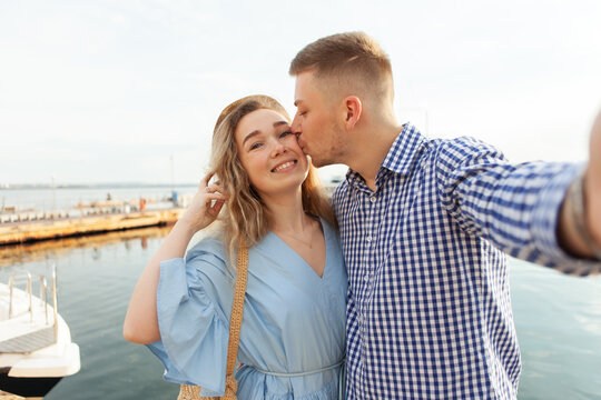 Selfie portrait of a young loving kissing couple on the background of the sea