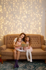 Happy loving family. pretty young mother reading a book to her pretty daughters