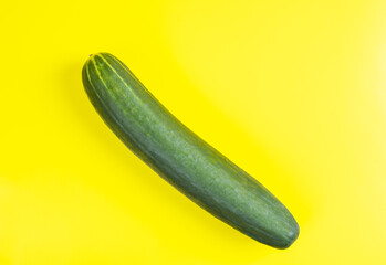 Fresh cucumber on yellow background, space for text