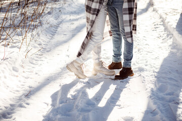 Man's and woman's legs in winter shoes on the snow and winter.