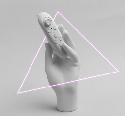White mannequin hand holding gamepad, neon triangle. Retro futurism