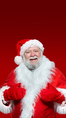 Closeup of a happy Santa Claus in a red coat, gloves and a hat, with his hands raised high, isolated red background.