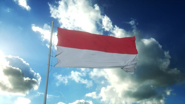 Flag of Indonesia waving at wind against beautiful blue sky