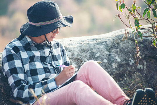 Traveller make note holiday trip on notebook. Asian Woman write and plan daily appointment schedule in  diary. Planner mark and count down date on calendar book.