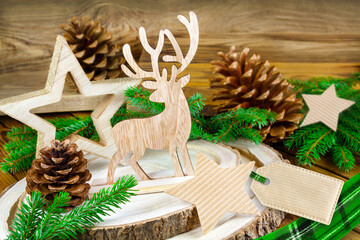 Natürliche grüne Dekoration für Weihnachten aus Holz und Rentier mit Tannenzapfen und Label...