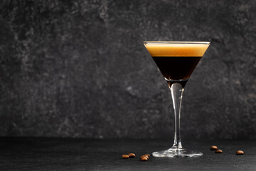 Espresso martini cocktail with vodka, coffee liqueur, syrup and ice, black background, bar tools