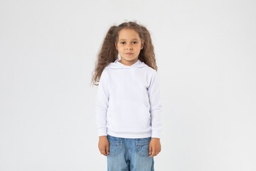 Obraz premium Little girl with two ponytails in a white hoodie. Mock-up.