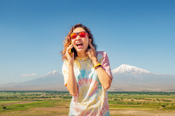 Woman is trying to talk on her mobile phone, but she does not hear well due to strong interference....