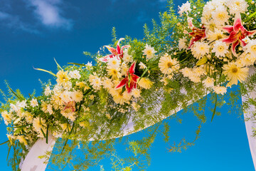 Wedding arch of flowers on the sky background, wedding ceremony of a tropical beach. High quality photo