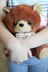 a small child is holding a brown teddy bear toy in his hands.