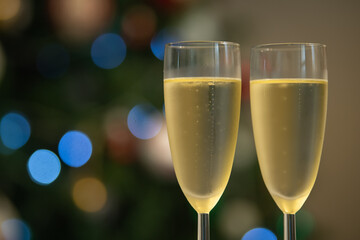 Champagne glasses over holiday bokeh blinking background, glasses with sparkling wine, celebration, party. High quality 4k footage
