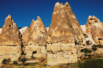 Close-up view of ancient cave houses in Goreme at sunny autumn morning. Underground city inside the rocks. Fabulous landscapes of the mountains and spectacular rocks formations of Cappadocia