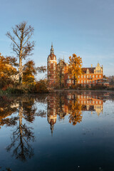 Prince Pueckler Park and castle reflected in water,Bad Muskau on German Polish border.Spectacular panoramic view of scenic fall landscape.UNESCO Site.Masterpiece on Neisse River.Tourist cultural place