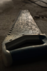 Hand saw for sawing foam block. Close-up, selective focus. Photo in dark key. Room renovation concept.
