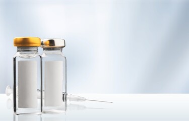 Bottle of Covid-19 vaccine to immunize from the Coronavirus and syringe on the desk