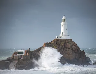 Foto op Plexiglas lighthouse on the rocks during the storm © Grzegorz