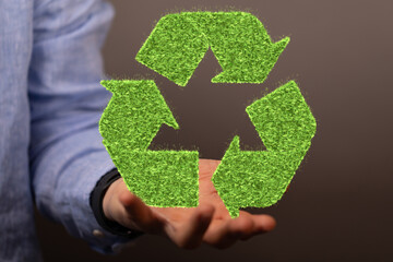 hand holding green recycle symbol