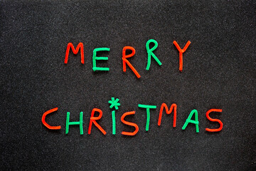Merry Christmas neon letters on a black glitter background