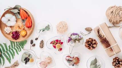 DIY ornaments with dried flowers and gift boxes on white background