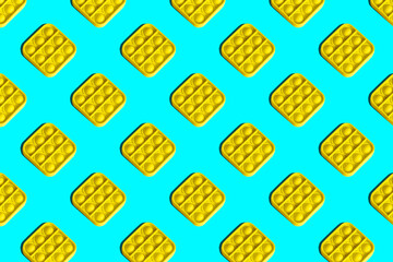 Seamless pattern of yellow trendy popit toys on a turquoise background. Design for children with repeating elements. Horizontal banner.