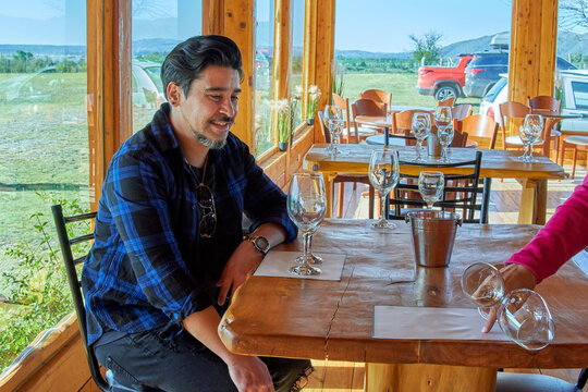 latin boy sitting in a winery after a guided tour of the vineyard for wine tasting. horizontal. Argentina