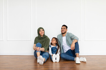 Happy muslim man, woman and girl planning repair