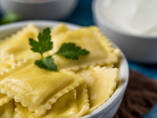 Macro photography. Delicious Italian ravioli with a green parsley leaf on top, two sauces in the background. Restaurant, hotel. cafe, home cooking, menu design, culinary blog.