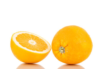 One half and one whole juicy bright yellow orange, close-up, isolated on white.