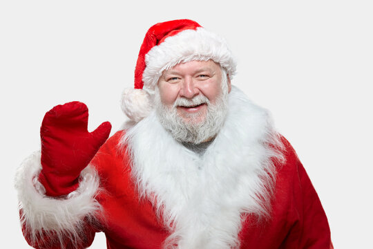 Image of a happy Santa Claus dressed in a red coat with gloves and a hat, isolated white background. Studio image.