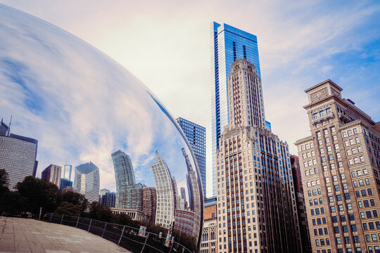 Skyscrapers reflecting in the famous sculpture Cloud Gate, nicknamed The Bean, in front of the skyline of Chicago, IL, USA