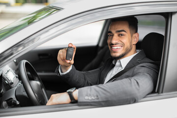 Handsome arabic businessman holding automatic car key