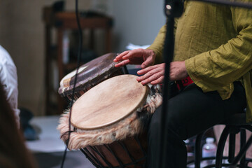 musician playing djembe, performing at a concert