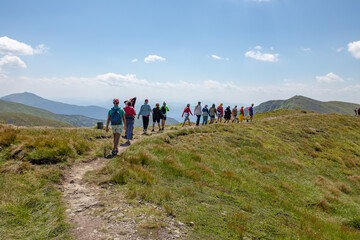 Obraz premium a large group of people goes hiking, walks in the mountains