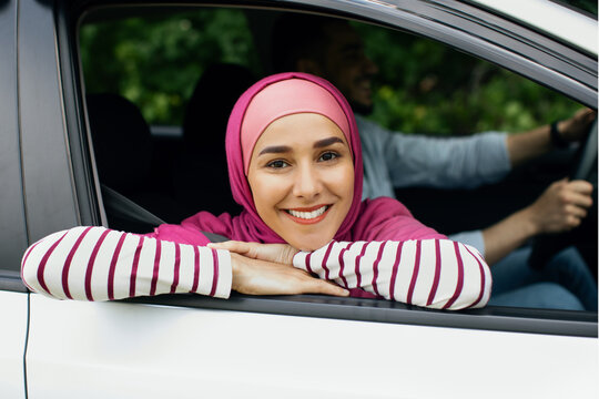 Closeup portrait of beautiful muslim woman in hijab leaning out of car - Powered by Adobe