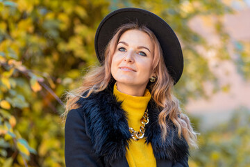 beautiful girl smile, young happy woman in hat in autumn in park. closeup portrait of stylish smiling lady in yellow clothes. fashion female fall outdoors