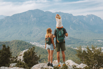 Family hiking parents with child outdoor travel in mountains active vacations lifestyle mother and...