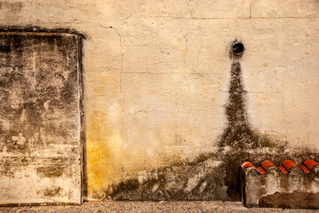 A wooden vintage window and a door on a plastered stone wall in the Spanish style.