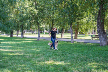  woman walks with her retriever in a summer park.